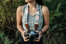Load image into Gallery viewer, Women wearing Wildtree Flower camera strap attached to Canon film camera
