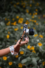 Load image into Gallery viewer, extended hand holding film camera with Wildtree Wildflower Floral camera wrist strap attached
