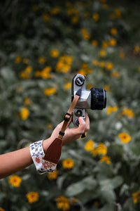 extended hand holding film camera with Wildtree Wildflower Floral camera wrist strap attached