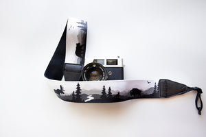 Wildtree Wildlife Camera Strap featuring Bear, Moose and Trees with mountain range background connected to Canon film camera