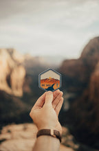 Load image into Gallery viewer, hand holding wildtree live wild sticker in zion national park utah
