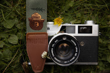 Load image into Gallery viewer, Smokey Bear camera strap next to flowers and film camera
