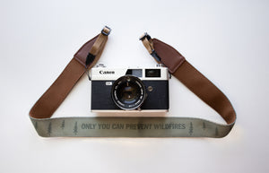 Wildtree Smokey Bear Camera Strap with words "Only you can prevent wildfires" attached to film camera