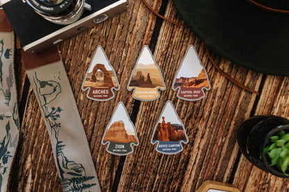 wood background with wildtree Utah national park stickers and national park strap