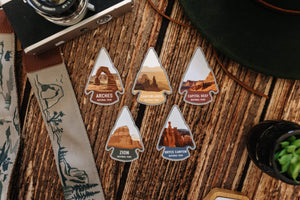 wood background with wildtree Utah national park stickers and national park strap