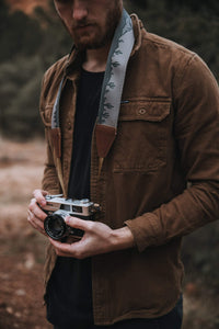 Man holding camera with Wildtree landscape Cacti camera strap around neck