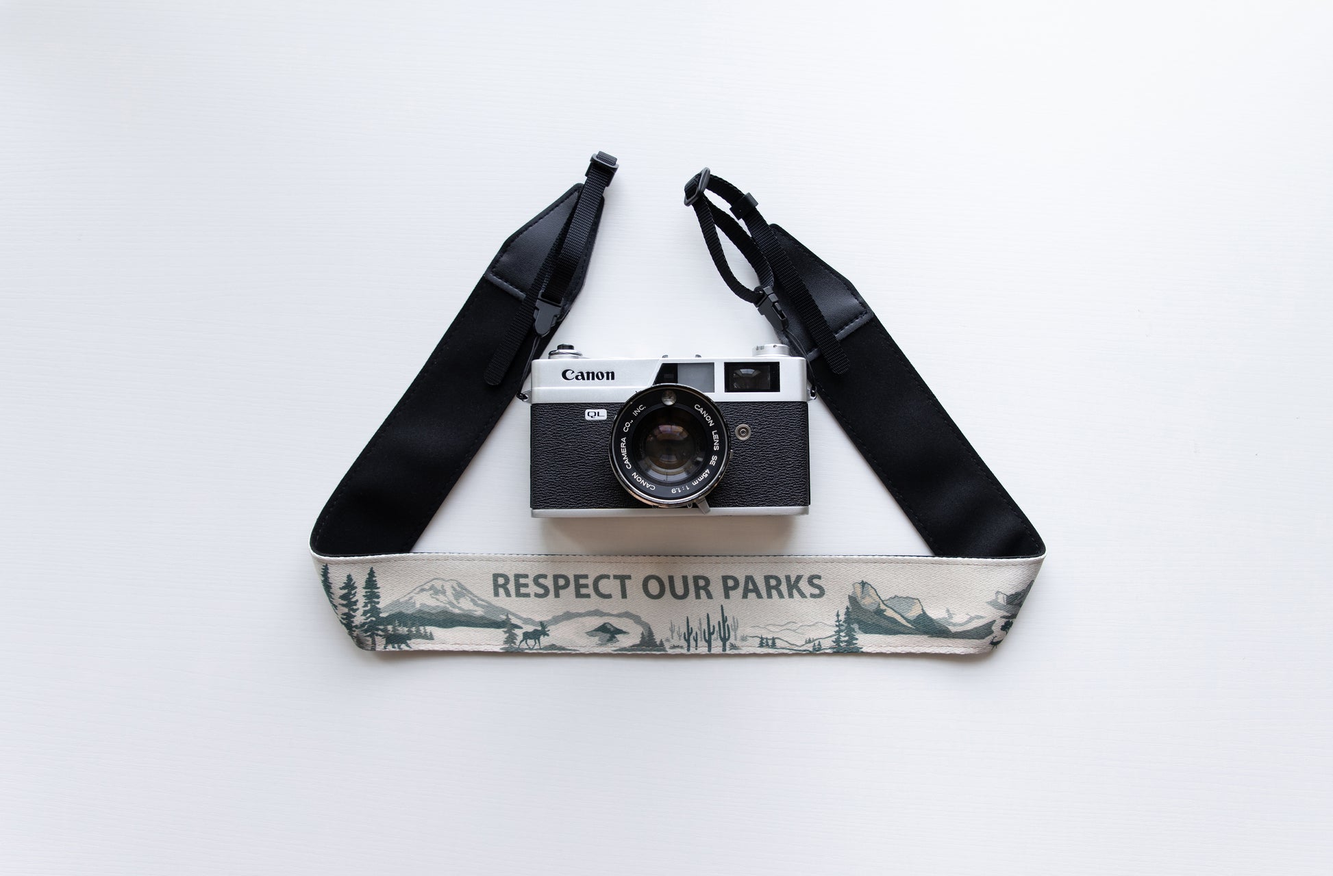 Wildree Respect our parks camera strap with black synthetic leather ends attached to film camera
