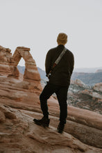 Load image into Gallery viewer, Man looking at Delicate Arch in Arches national park wearing National park inspired camera strap
