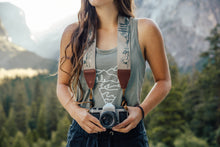 Load image into Gallery viewer, Women holding camera with Wildtree national park camera strap around neck
