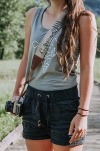 Women holding camera with Wildtree national park camera strap over shoulder