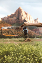 Load image into Gallery viewer, extended arm holding Wildtree national park camera strap in zion national park
