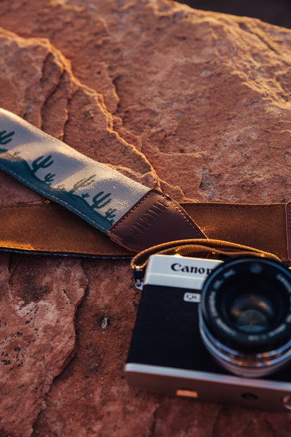 Wildtree landscape camers strap sitting on rock attached to canon camera