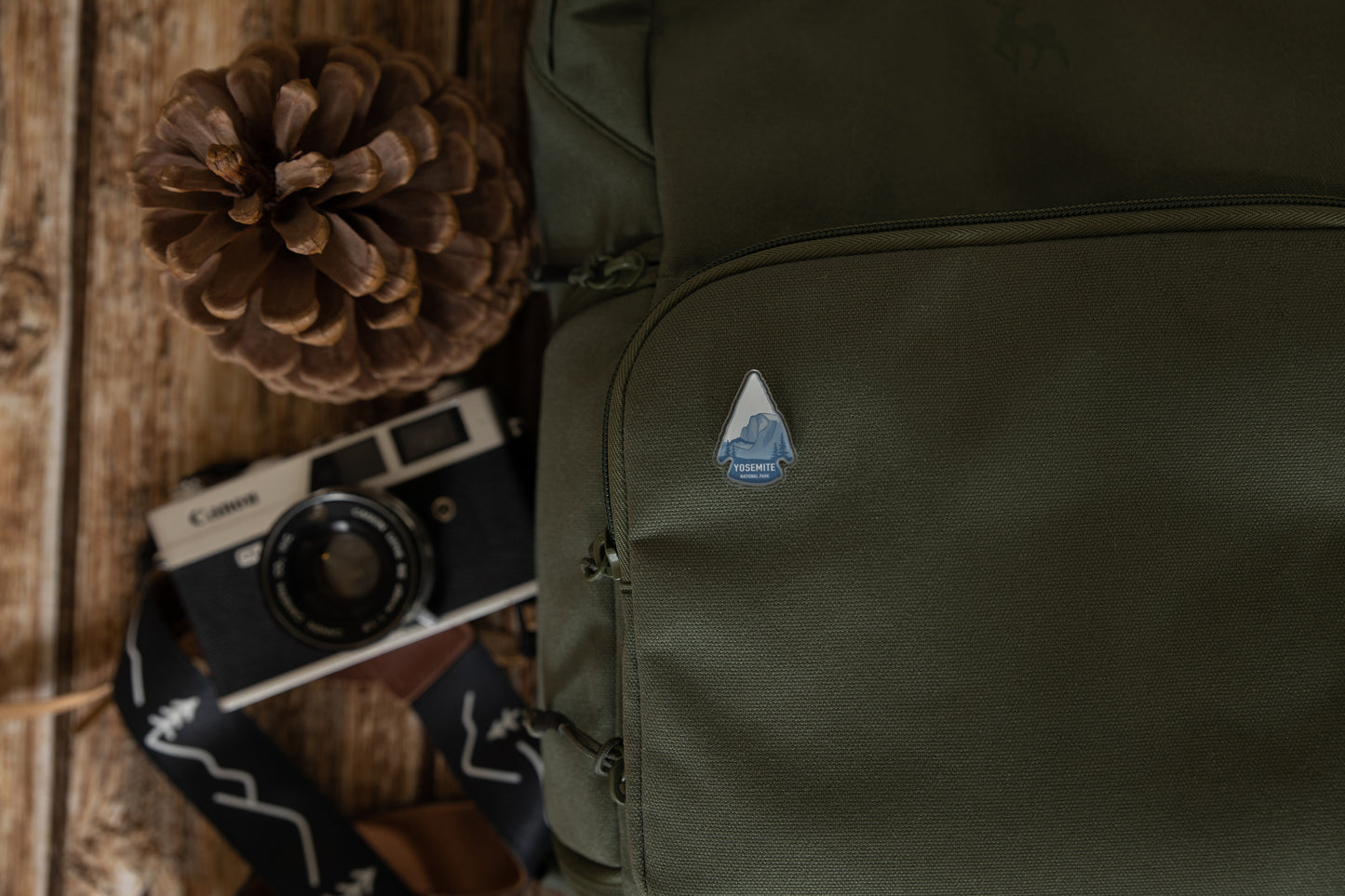 Yosemite National Park pin in shape of arrow head pinned on back pack